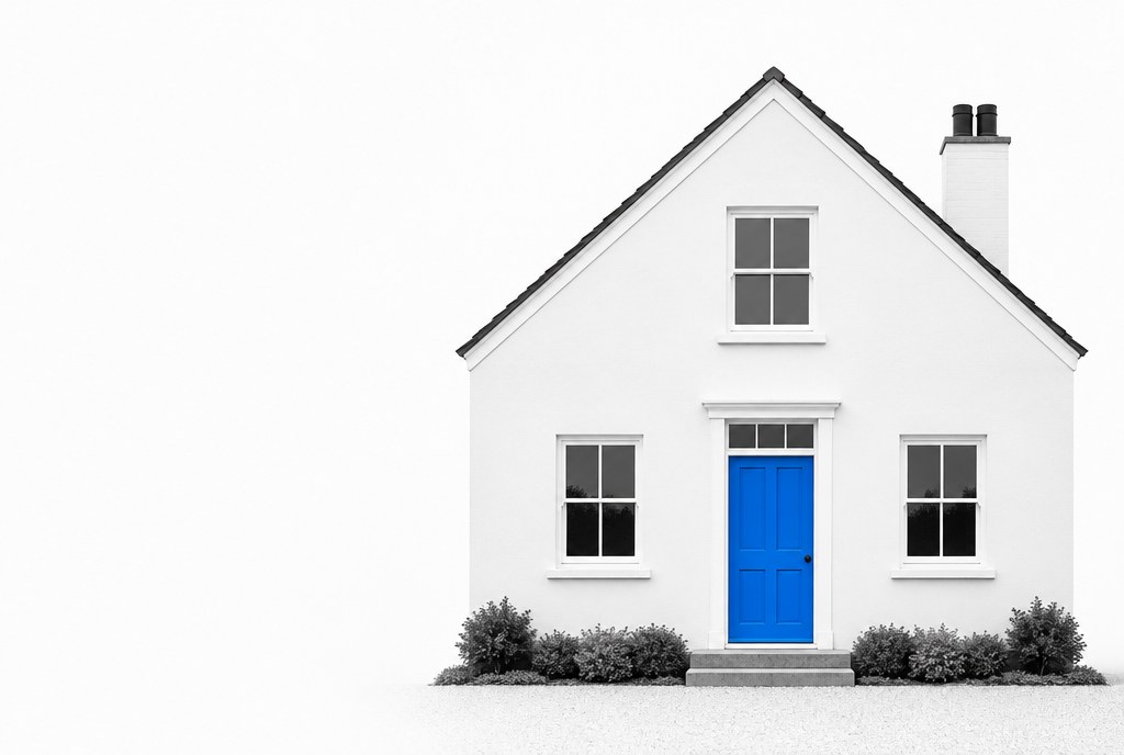 A white house in black and white with a blue front door